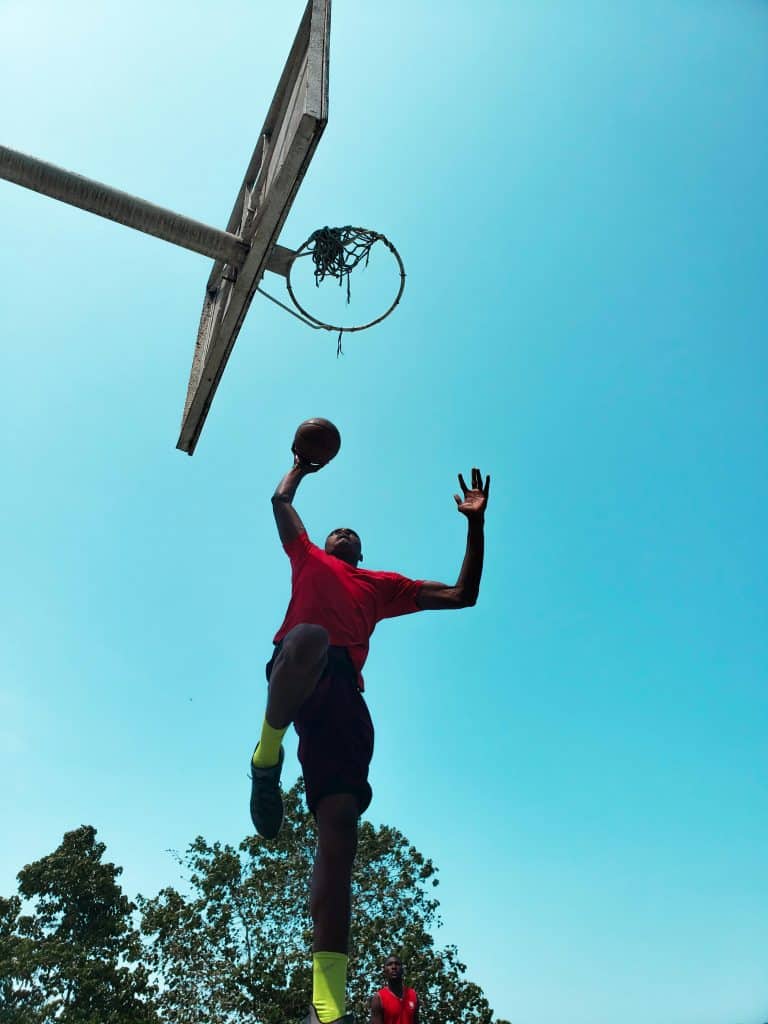 Basketball player mid-air near hoop representing athleticism and power, reflecting the focus on the 1985 NBA Draft Best Players.