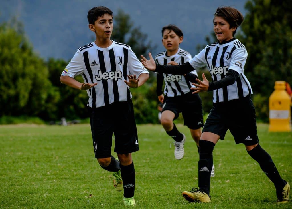 Young players in Juventus jerseys celebrating a goal, symbolizing the legacy of the Best Juventus Players.