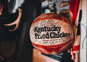 A basketball with Kentucky Fried Chicken logo representing the tradition and legacy of Best Kentucky High School Basketball Players.