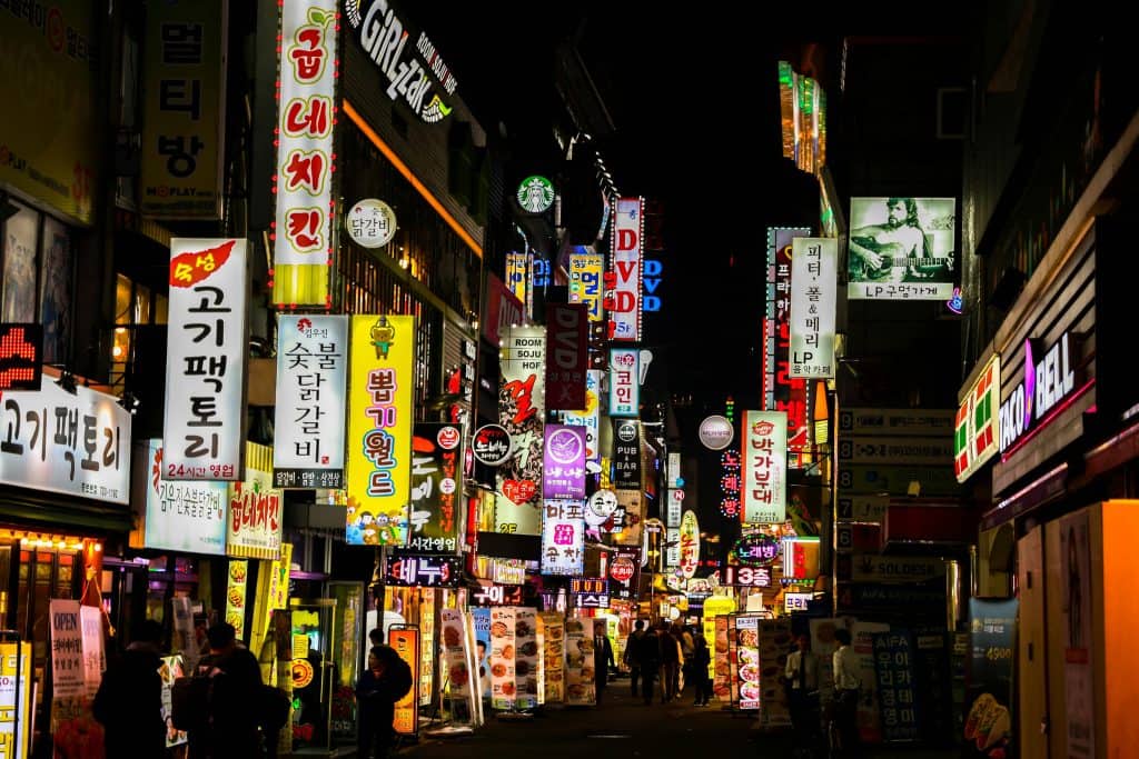 Street in South Korea at night with colorful neon signs, showcasing the vibrant culture and environment of the country known for producing the Best Korean Soccer Players.
