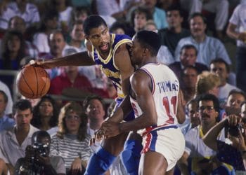 Magic Johnson of the Los Angeles Lakers backing down Isiah Thomas of the Detroit Pistons during an intense matchup, showcasing two of the best NBA players of the 80s in action.