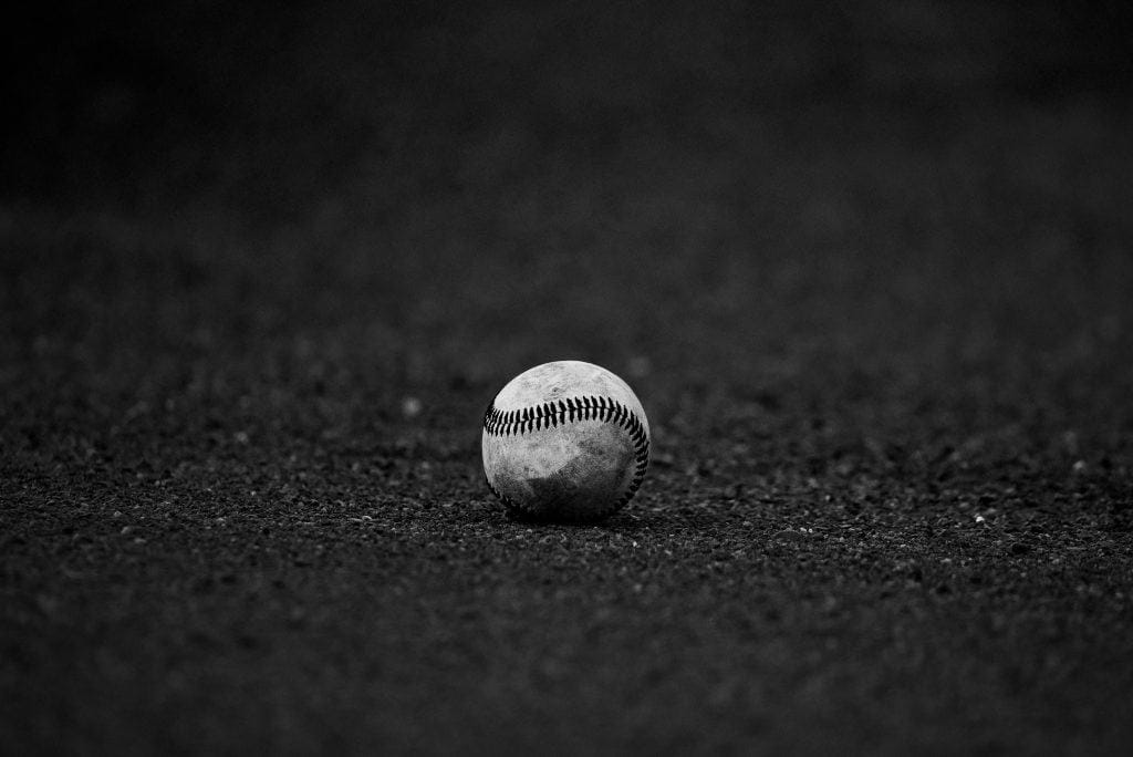 A baseball resting on a field, representing the era of the Best Baseball Players of the 60s and 70s.
