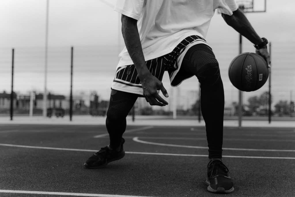 Black and white photo of an NBA player about to perform a crossover dribble, representing the Top 10 Best Ball Handlers in NBA History