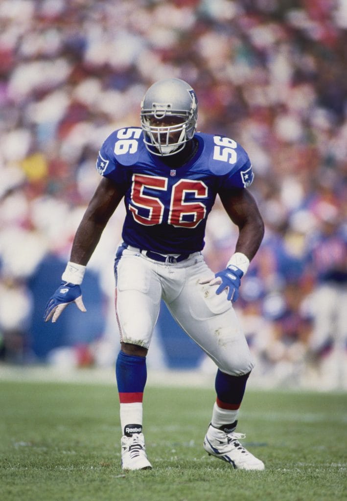 Andre Tippett in New England Patriots uniform preparing for a play on defense.