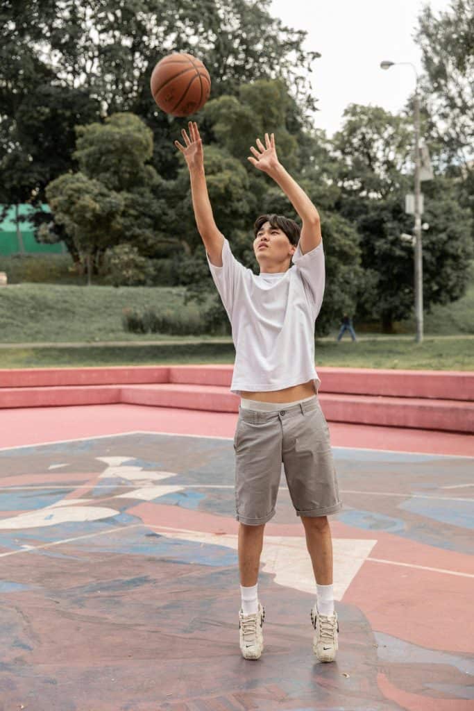 Best Asian Basketball Players of All Time. A young Asian basketball player shooting on an outdoor court, symbolizing top Asian basketball talents.