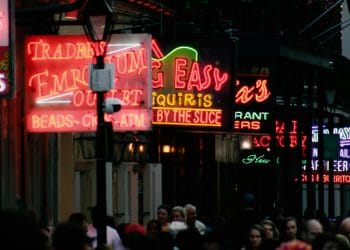 Crowded street scene in Louisiana with neon lights and vibrant nightlife, symbolizing the culture and where Best NBA Players From Louisiana hang out.