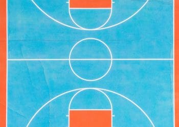 Aerial view of a vintage-style basketball court with vibrant red and blue colors, symbolizing where Best NBA Players In The 70s used to play.
