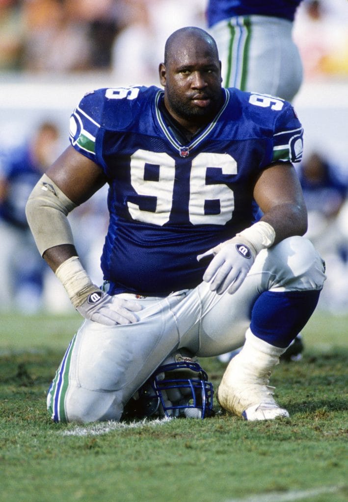Cortez Kennedy of the Seattle Seahawks kneeling on the field during a game, wearing jersey number 96.