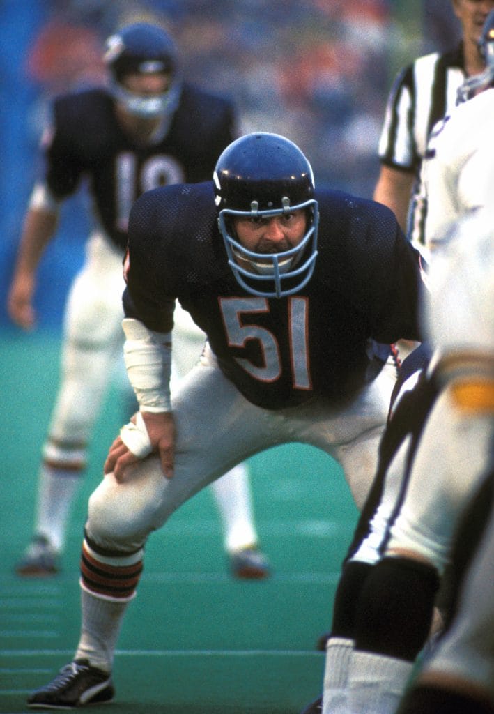 Dick Butkus of the Chicago Bears in a defensive pre-snap stance, focused on the opposing offense during a game.