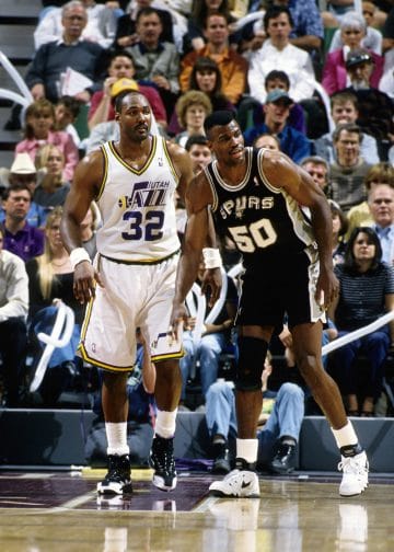 Karl Malone of the Utah Jazz and David Robinson of the San Antonio Spurs stand near each other during a game.