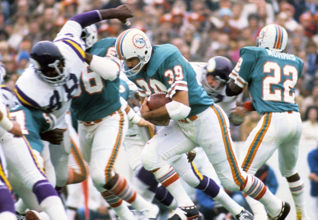 Larry Csonka powers through defenders during a Miami Dolphins game.