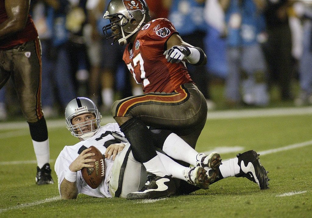 Tampa Bay Buccaneers defender Simeon Rice sacking Oakland Raiders quarterback during a football game.