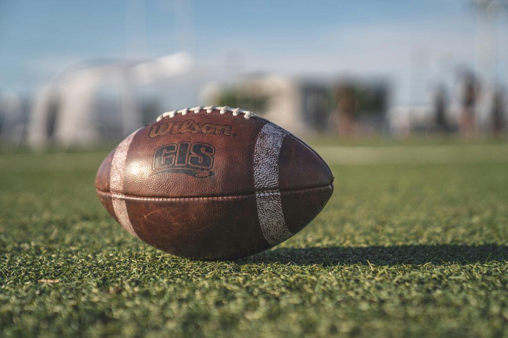 Close-up of a football on a grassy field, representing the competitive spirit of the Top 10 JUCO Football Teams in junior college football.