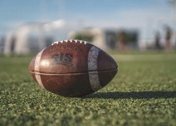 Close-up of a football on a grassy field, representing the competitive spirit of the Top 10 JUCO Football Teams in junior college football.