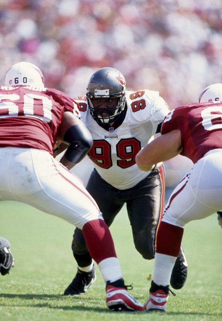 Warren Sapp of the Tampa Bay Buccaneers lines up against the Arizona Cardinals’ offensive line, ready for the play.