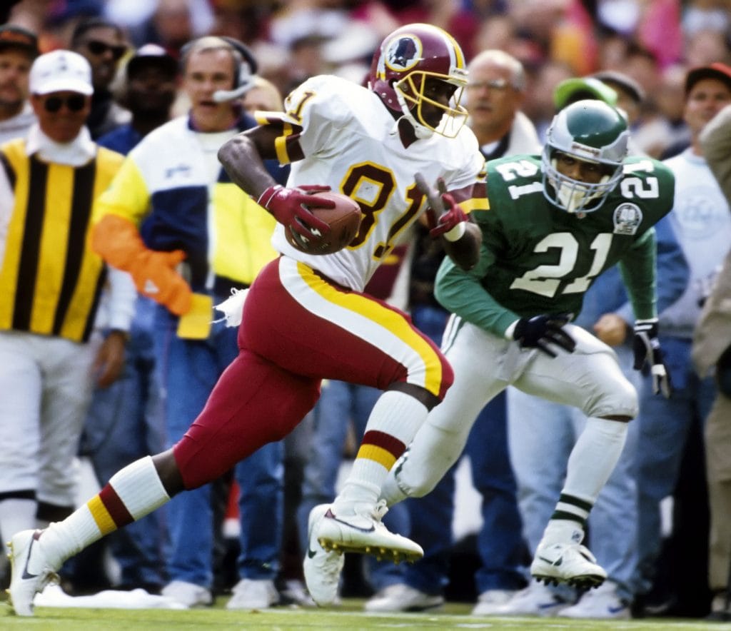 Art Monk of the Washington Redskins, wearing number 81, running with the football while being chased by an Eagles defender during a game.