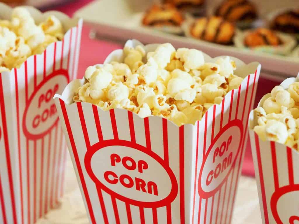 A close-up of popcorn in classic red-and-white striped containers, symbolizing a movie setting for enjoying the best fictional football players on screen