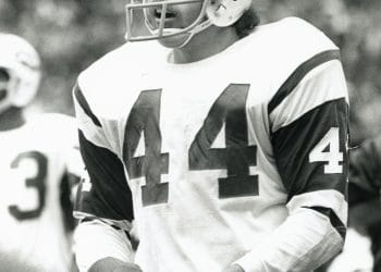 John Riggins, one of the best white football players, in his New York Jets uniform during a game, showcasing his grit and talent on the field.