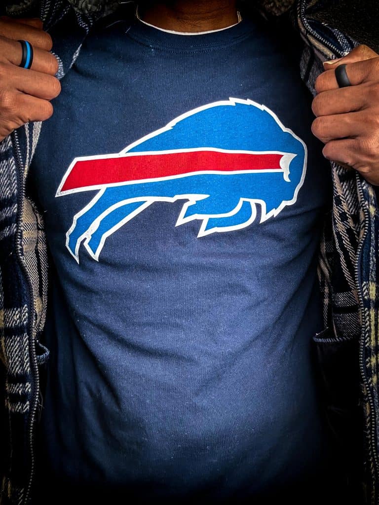 Close-up of a person wearing a Buffalo Bills logo shirt, representing the pride of Bills 11 Best Players of All Time.