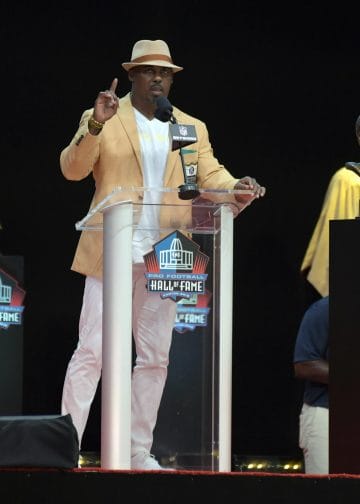 Brian Dawkins speaking at the Hall of Fame podium with his bust.