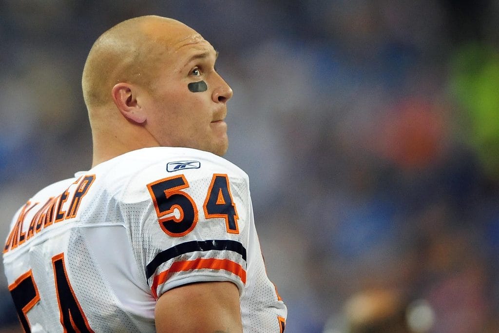 Brian Urlacher in a white Chicago Bears jersey, looking upwards with eye black under his eyes.