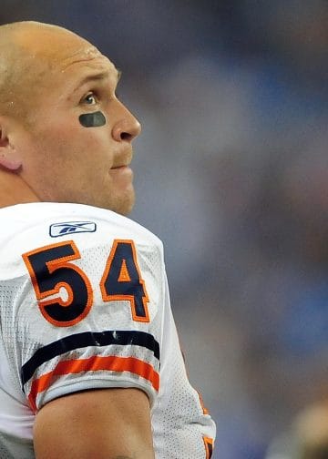 Brian Urlacher in a white Chicago Bears jersey, looking upwards with eye black under his eyes.
