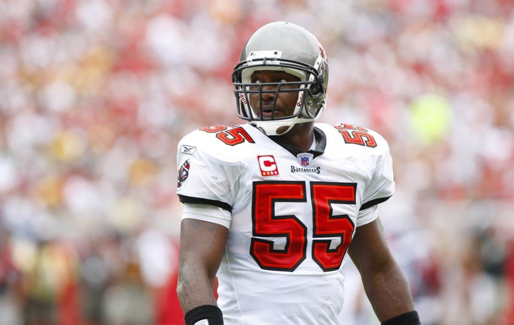 Derrick Brooks of the Tampa Bay Buccaneers in a white jersey with the number 55, looking across the field during a game.