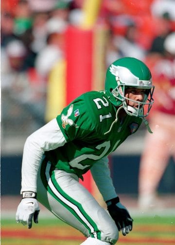 Eric Allen poised in a defensive stance wearing his Eagles jersey.