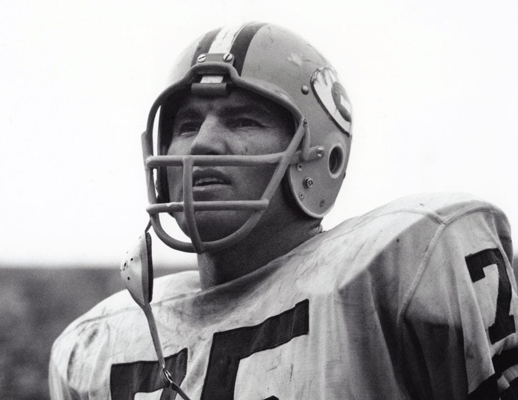 Black-and-white portrait of Forrest Gregg in a Packers helmet, showing a focused expression on the field and representing one of Top 10 White Offensive Linemen of All Time. 