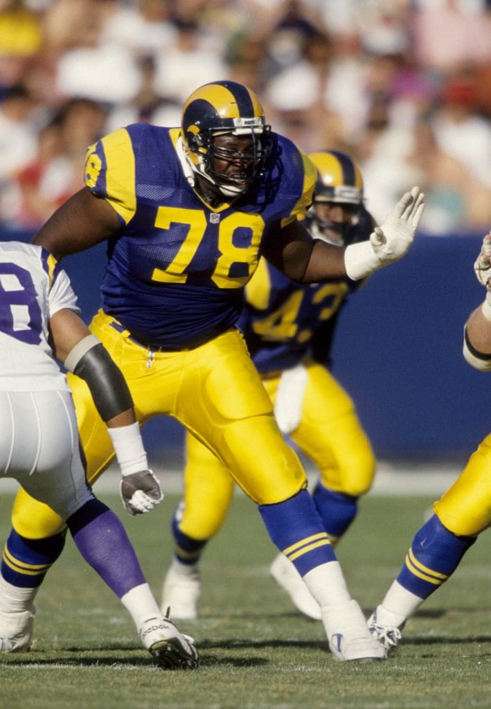 Orlando Pace of the St. Louis Rams blocking with precision during an intense NFL game. One of the Top 10 Los Angeles Rams of All Time.