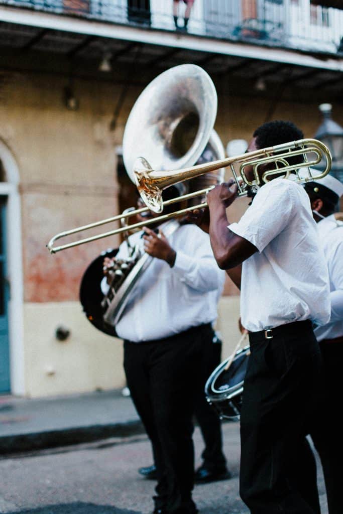 A brass band marching through a Louisiana street, capturing the vibrant culture that surrounds the LSU 10 Best Defensive Players.