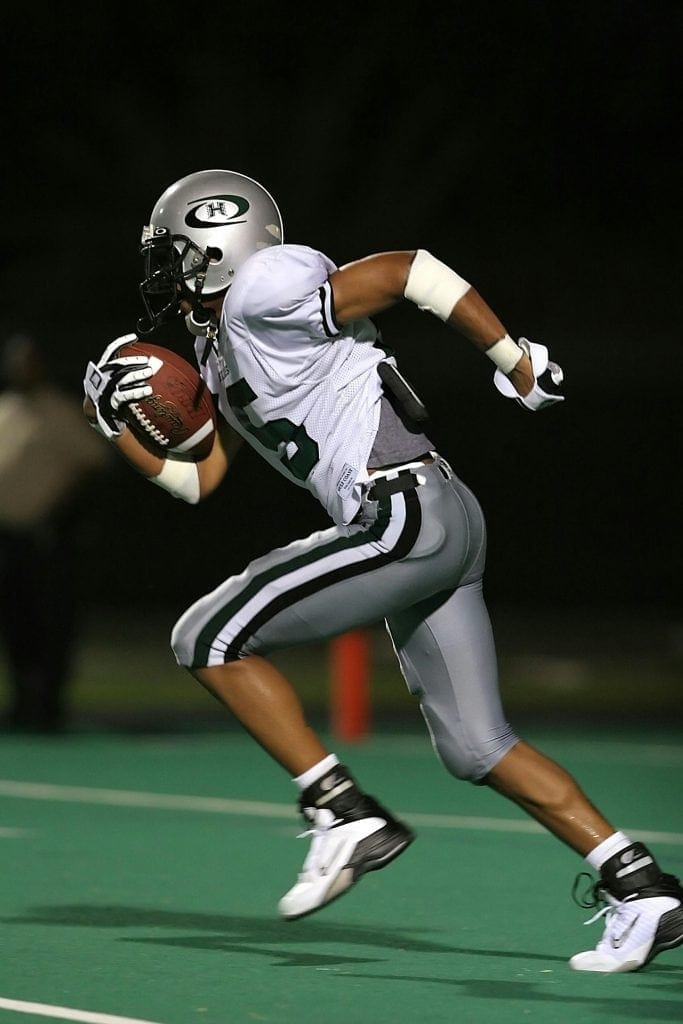 A player sprinting on the field, showcasing the dedication and skill of the Top 10 NAIA Football Teams in college football.