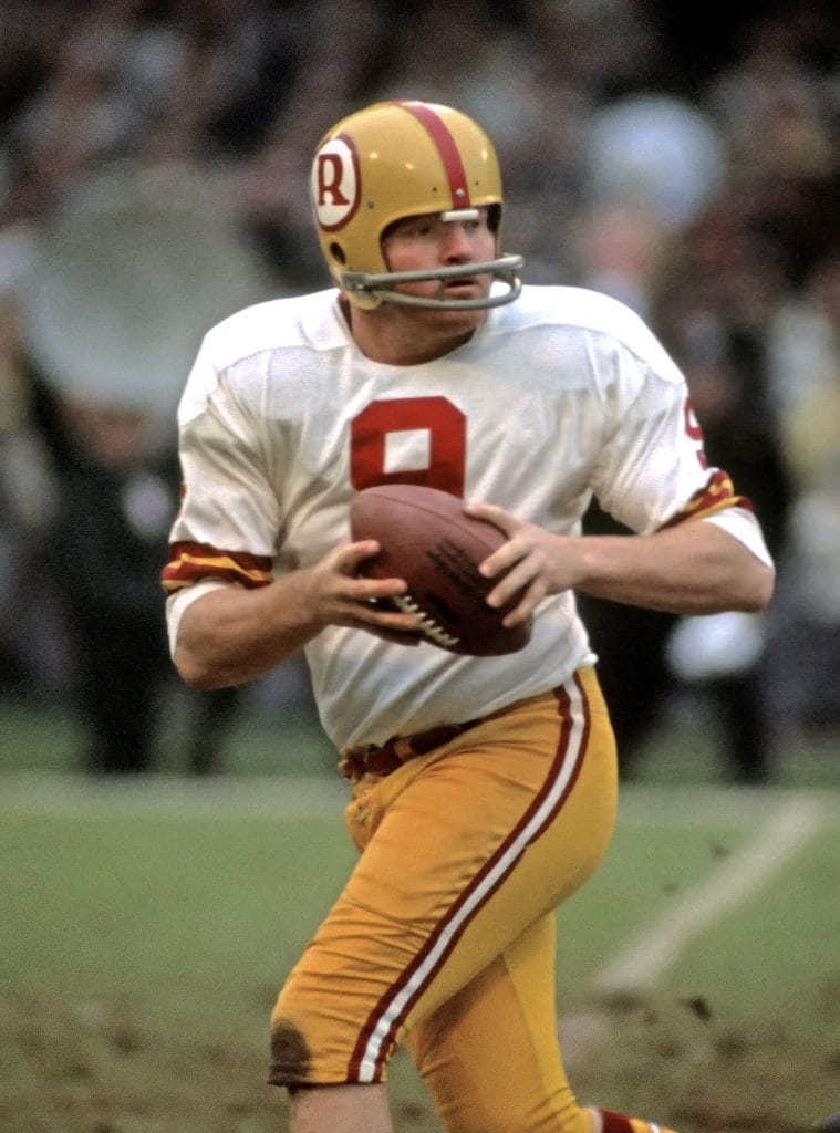 Sonny Jurgensen of the Washington Redskins holds the ball, preparing to pass during a game.