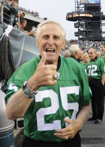 Tommy McDonald giving a thumbs up in an Eagles jersey at a game event.