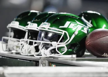 Top 10 New York Jets of All Time helmets on the sideline with football