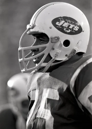 Winston Hill looking focused in his New York Jets helmet during a game.