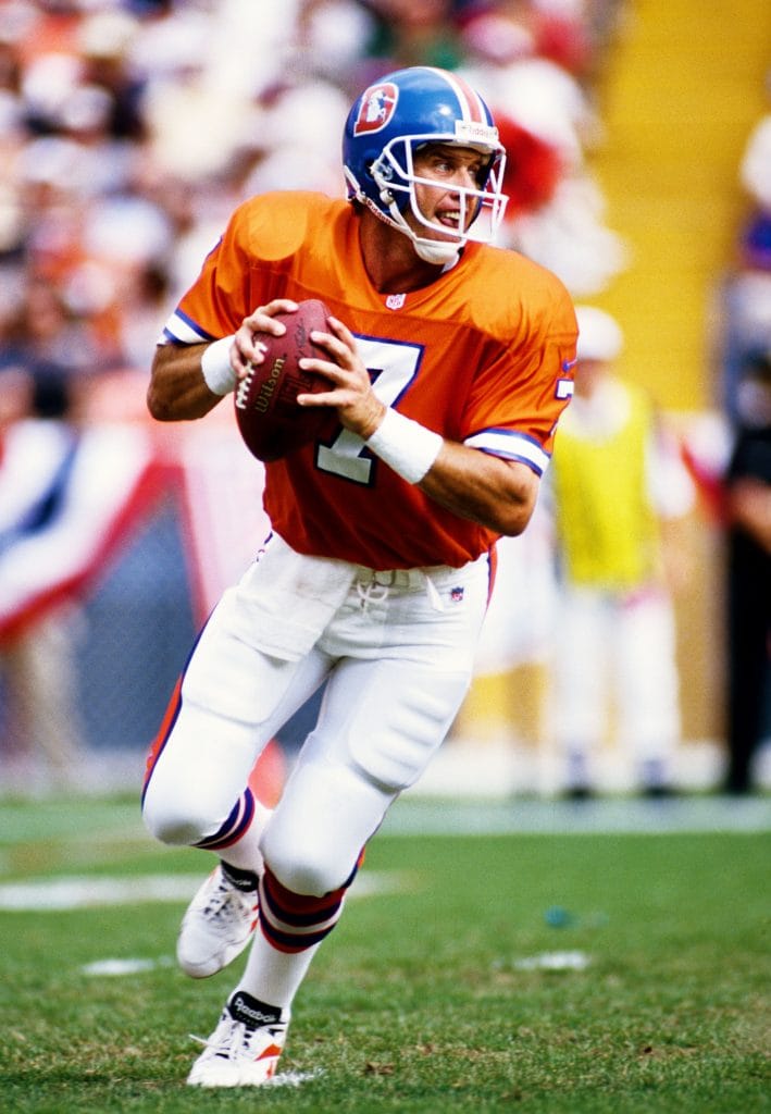 John Elway preparing to throw a pass during a Denver Broncos game.