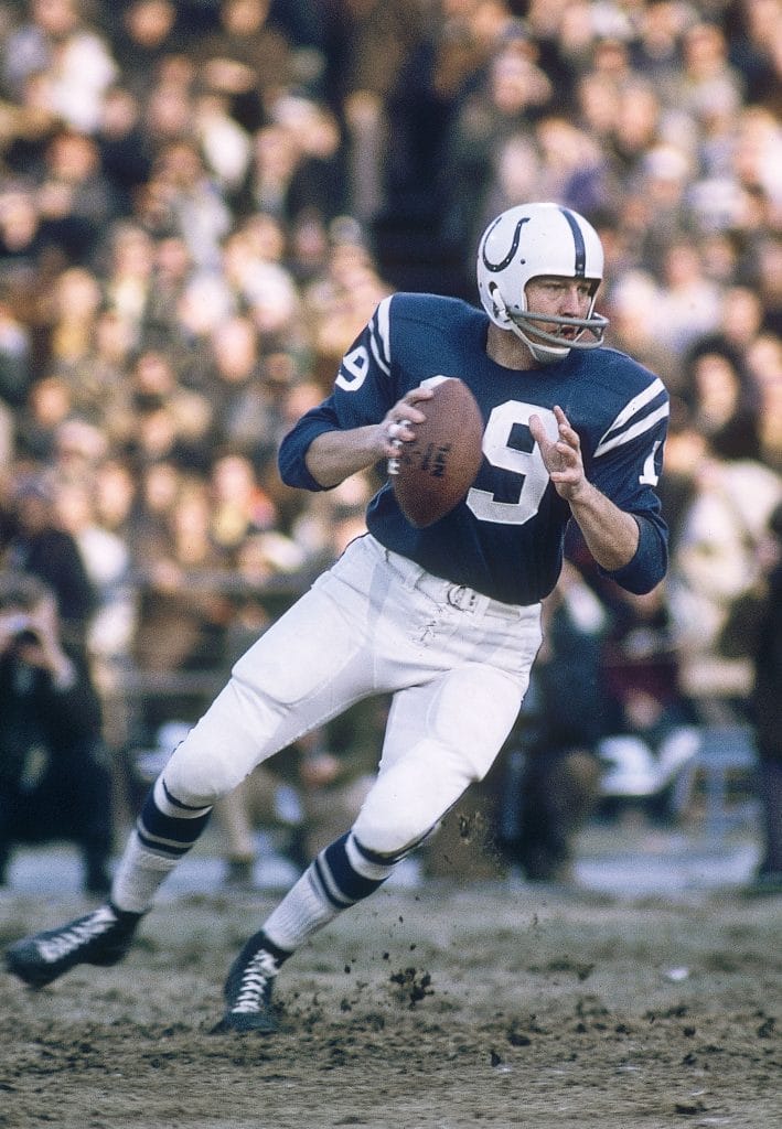 Johnny Unitas of the Baltimore Colts running with the ball during an NFL game.