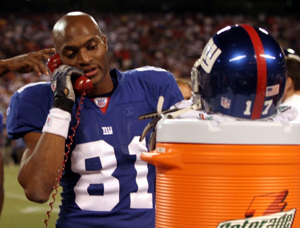 New York Giants wide receiver Amani Toomer humorously uses a sideline Gatorade phone during a game.