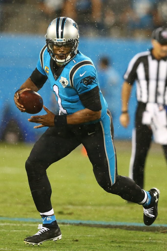 Cam Newton of the Carolina Panthers scrambling with the football during a rainy game. The #1 player in the Top 10 Carolina Panthers of All Time list. 