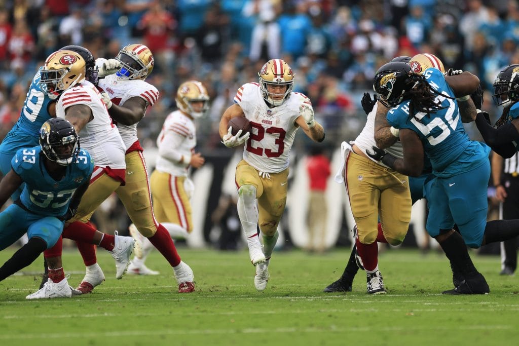San Francisco 49ers running back Christian McCaffrey breaking through defenders during a game against the Jacksonville Jaguars.