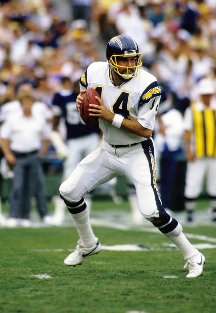 Dan Fouts, quarterback of the San Diego Chargers, wearing jersey number 14, preparing to pass during an NFL game.