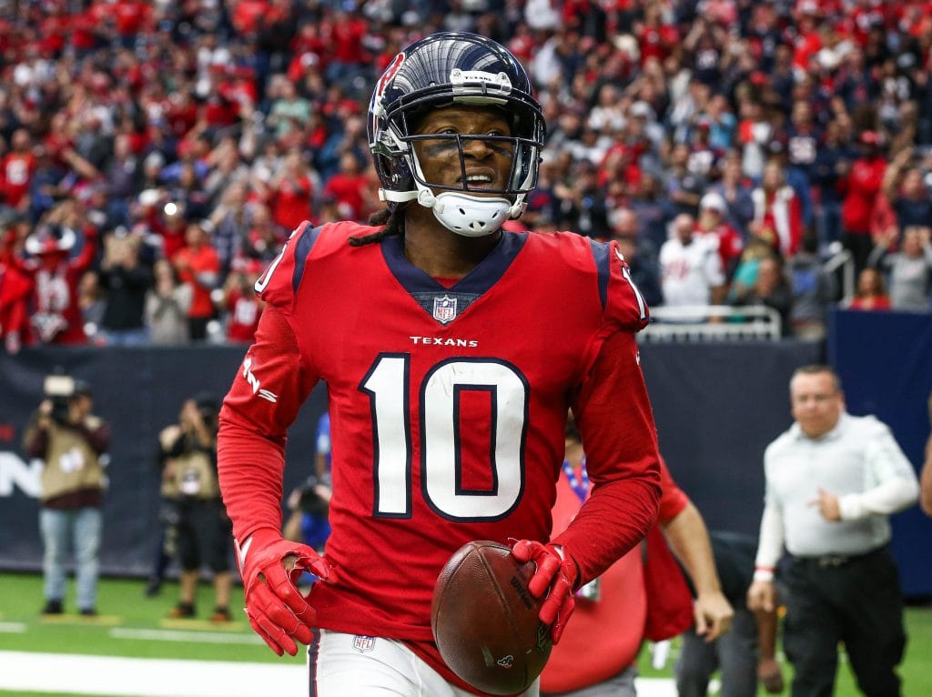 DeAndre Hopkins celebrates a play while holding a football in a Houston Texans game.