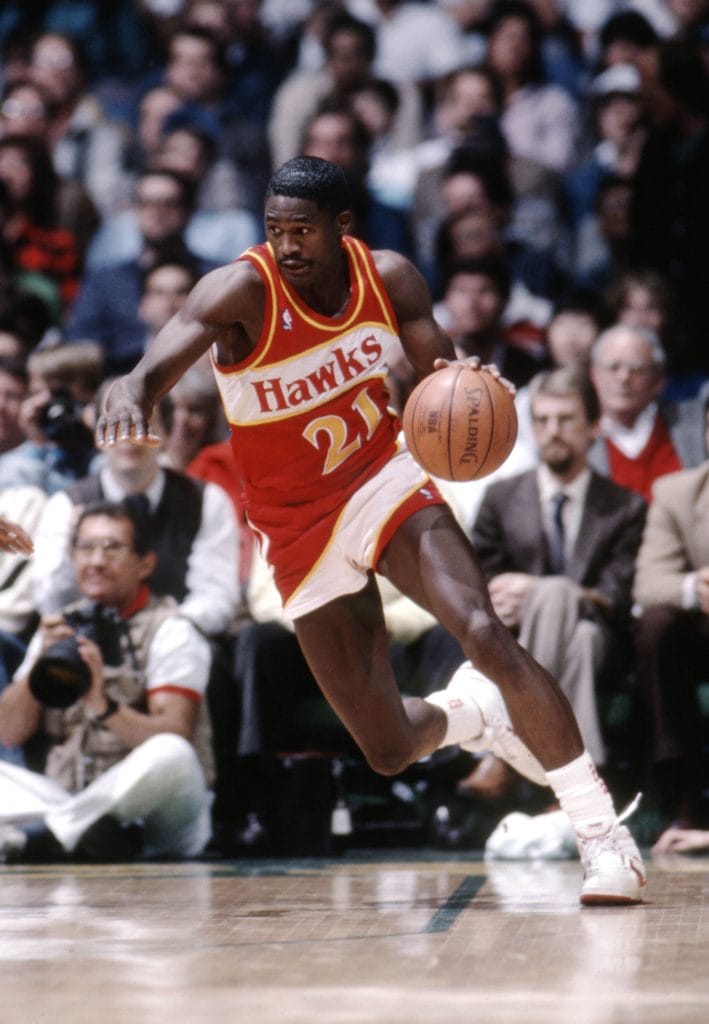 Dominique Wilkins dribbling in an Atlanta Hawks uniform during a game.