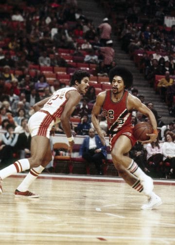 Fred Hilton, Buffalo Braves player, driving toward the basket during a competitive NBA game.