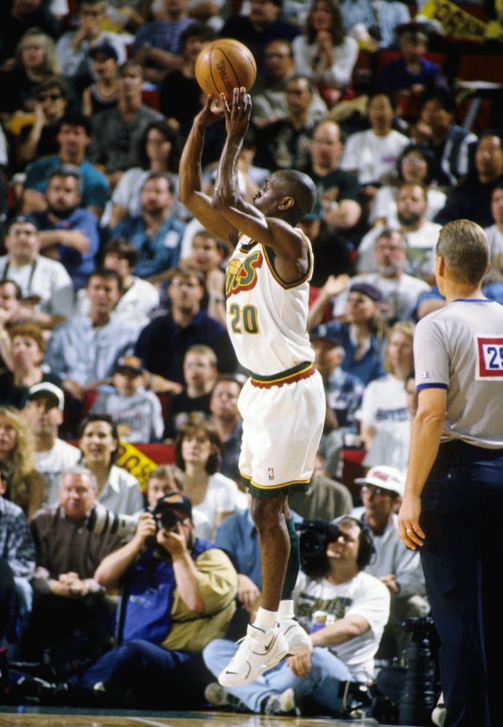 Gary Payton performing a jump shot in a Seattle SuperSonics game, showcasing his scoring ability and control.
