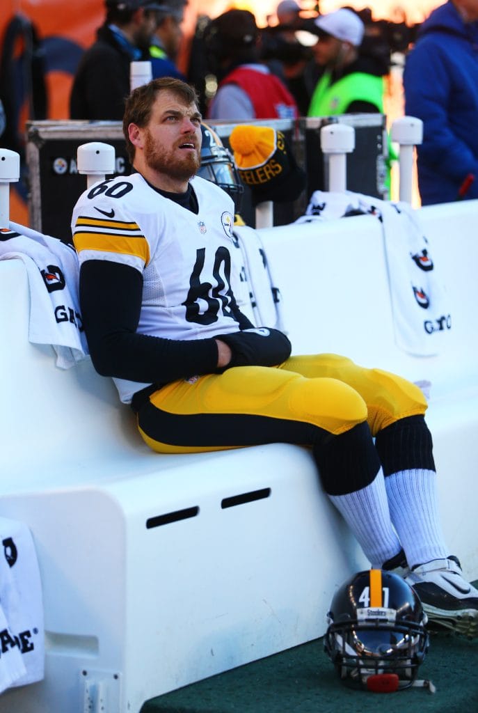 Greg Warren, one of the best white NFL players of all time, sitting on the sideline in his Steelers uniform.