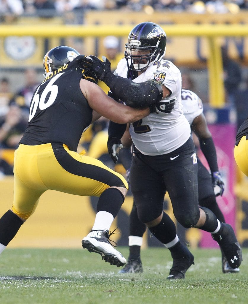 Baltimore Ravens defensive lineman Haloti Ngata engages in a fierce block against the Pittsburgh Steelers during a game.