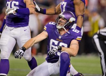 Jared Allen celebrating a sack on the field as one of the top 10 defense ends of all time in his Minnesota Vikings uniform during a primetime game.