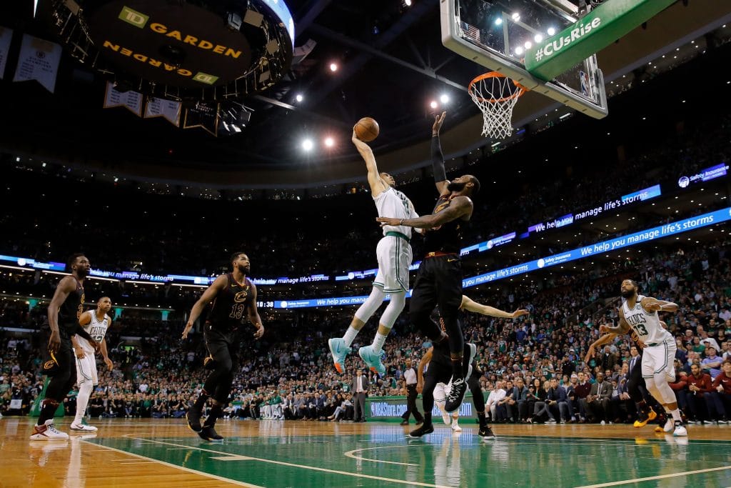 Jayson Tatum soaring for a dunk in a Boston Celtics jersey against the Cleveland Cavaliers and LeBron James.
